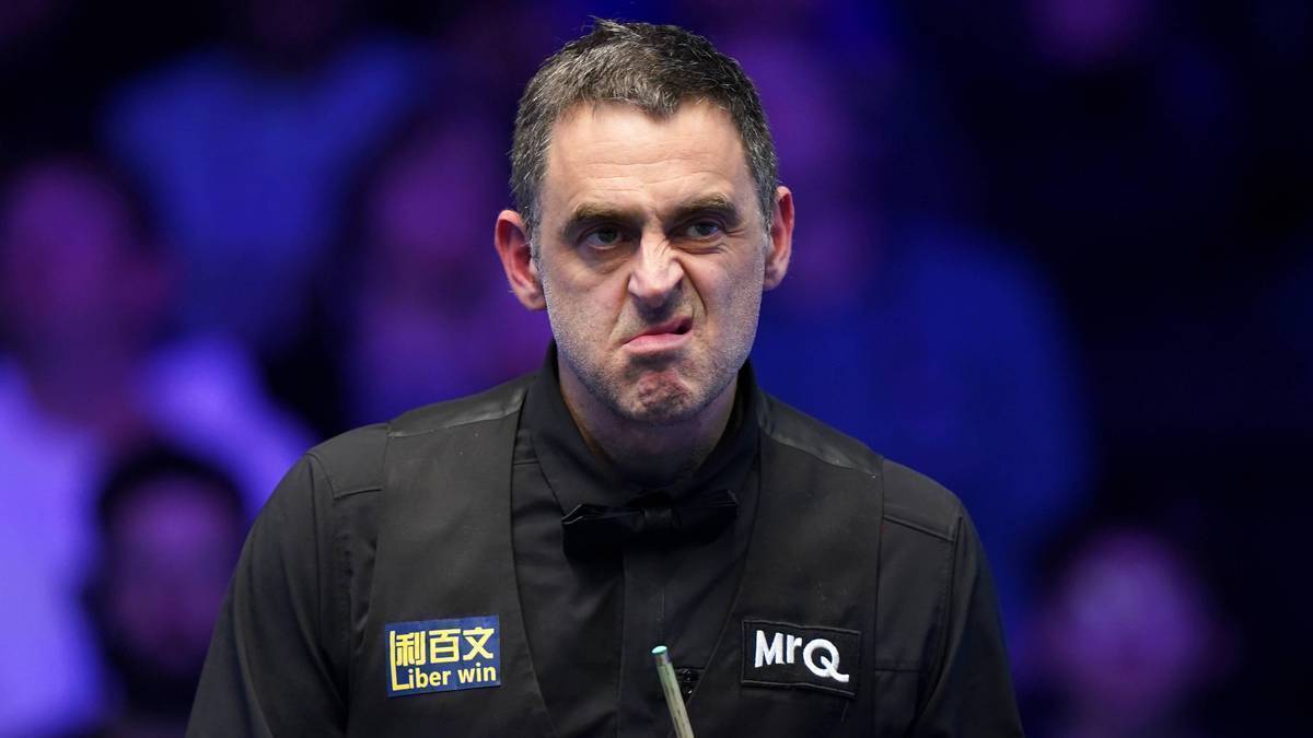 Ronnie O'Sullivan, angielski snookerzysta, w czarnym stroju z logotypami sponsorów, podczas meczu.