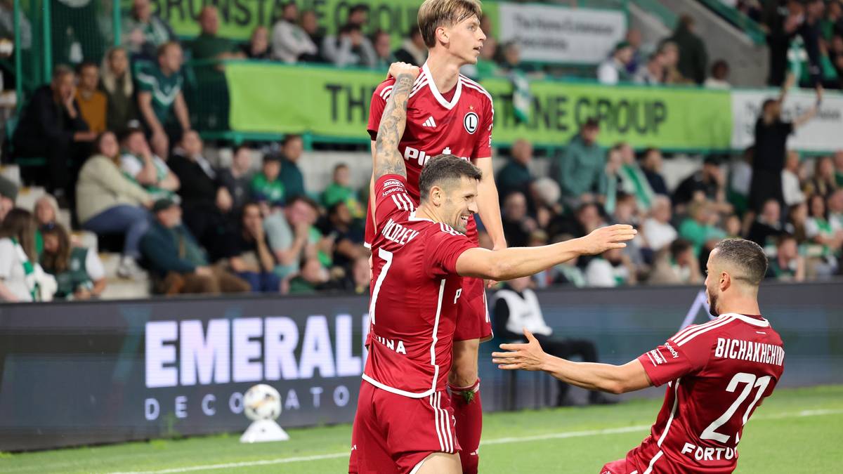 Piłkarze Legii Warszawa w czerwonych strojach celebrują zwycięstwo na boisku.