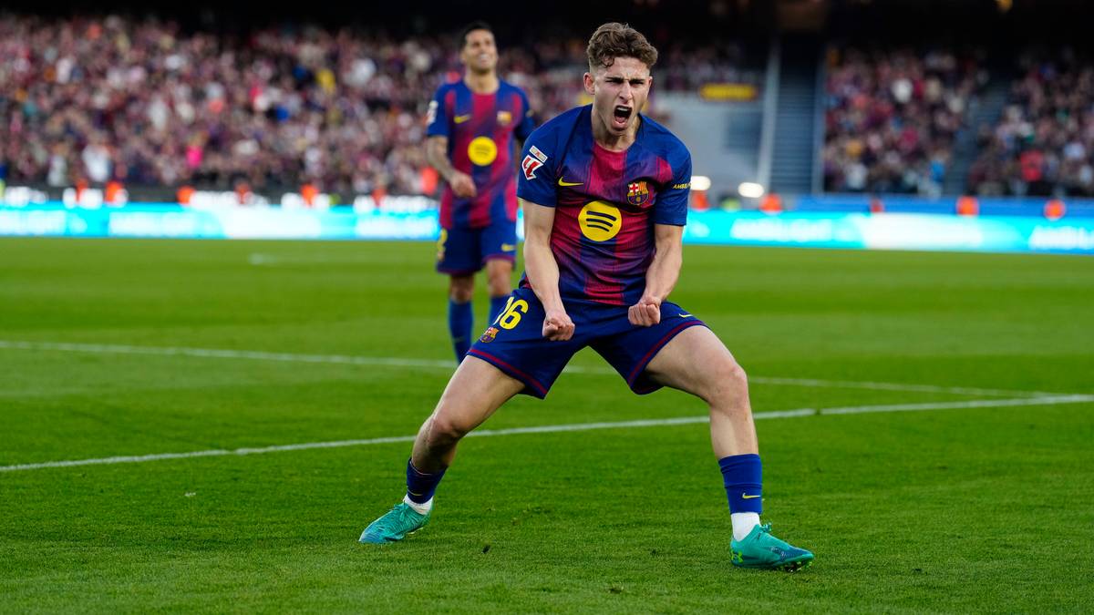 Piłkarz FC Barcelony świętuje gola na boisku, ubrany w niebiesko-bordowy str&oacute;j.