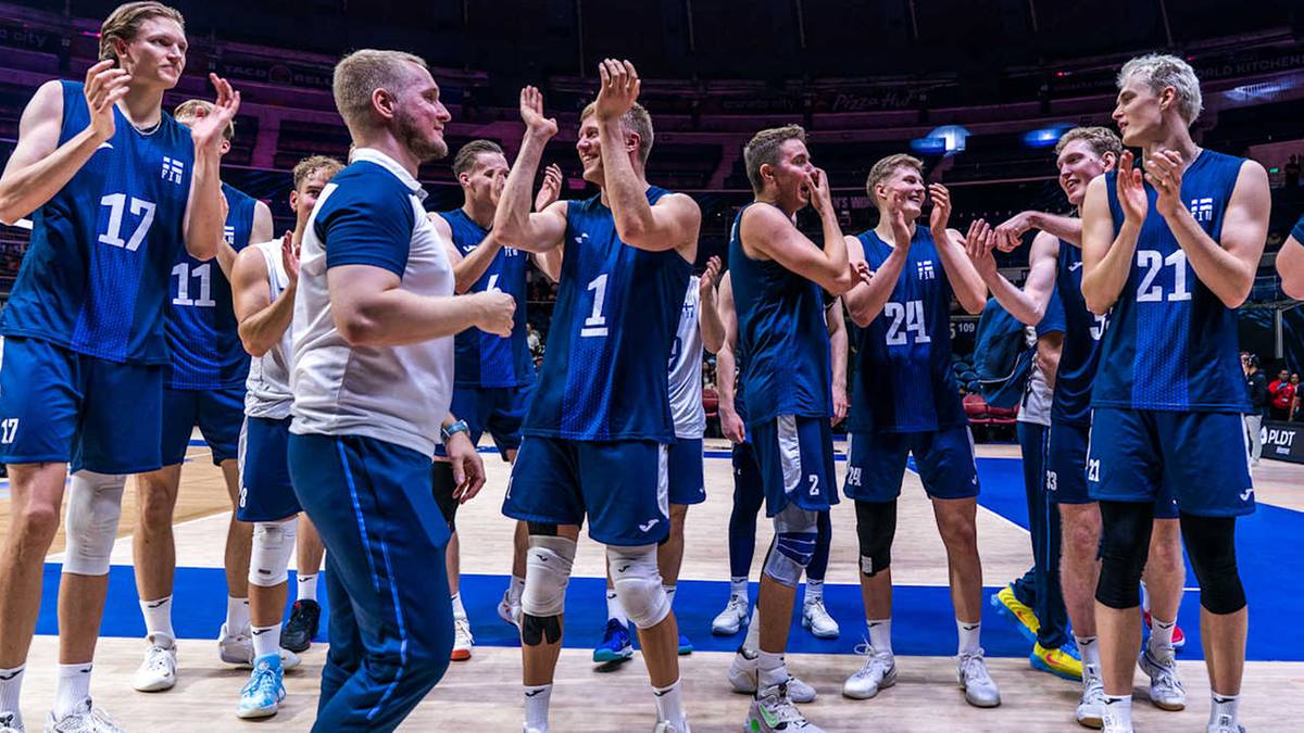 Siatkarze w niebieskich strojach świętują na boisku podczas meczu.