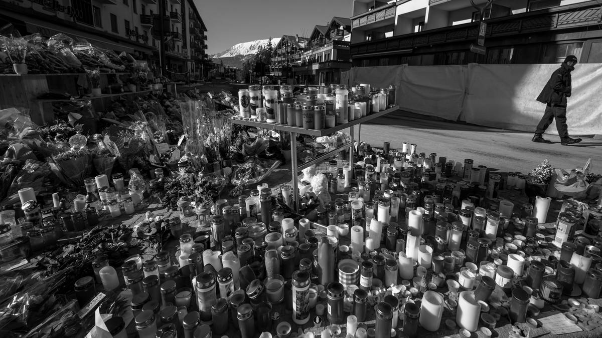 Obszar po pożarze z ustawionymi zniczami i kwiatami.