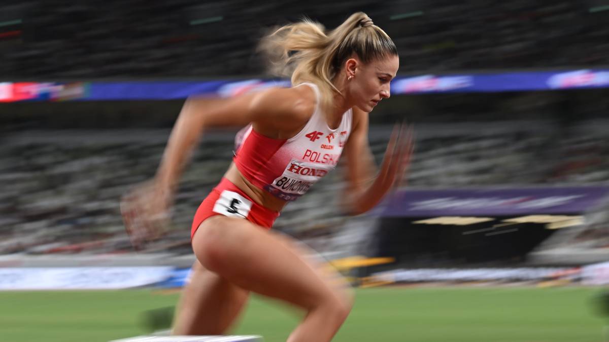 Ateltka w stroju sportowym biegnie podczas zawodów lekkoatletycznych.