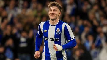 Piłkarz FC Porto w niebiesko-białym stroju biegnie po murawie stadionu.