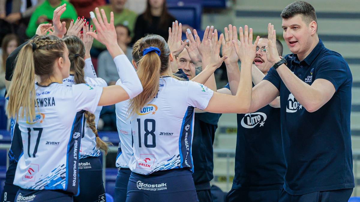 Siatkarze i siatkarki świętują na boisku, unosząc ręce do góry.