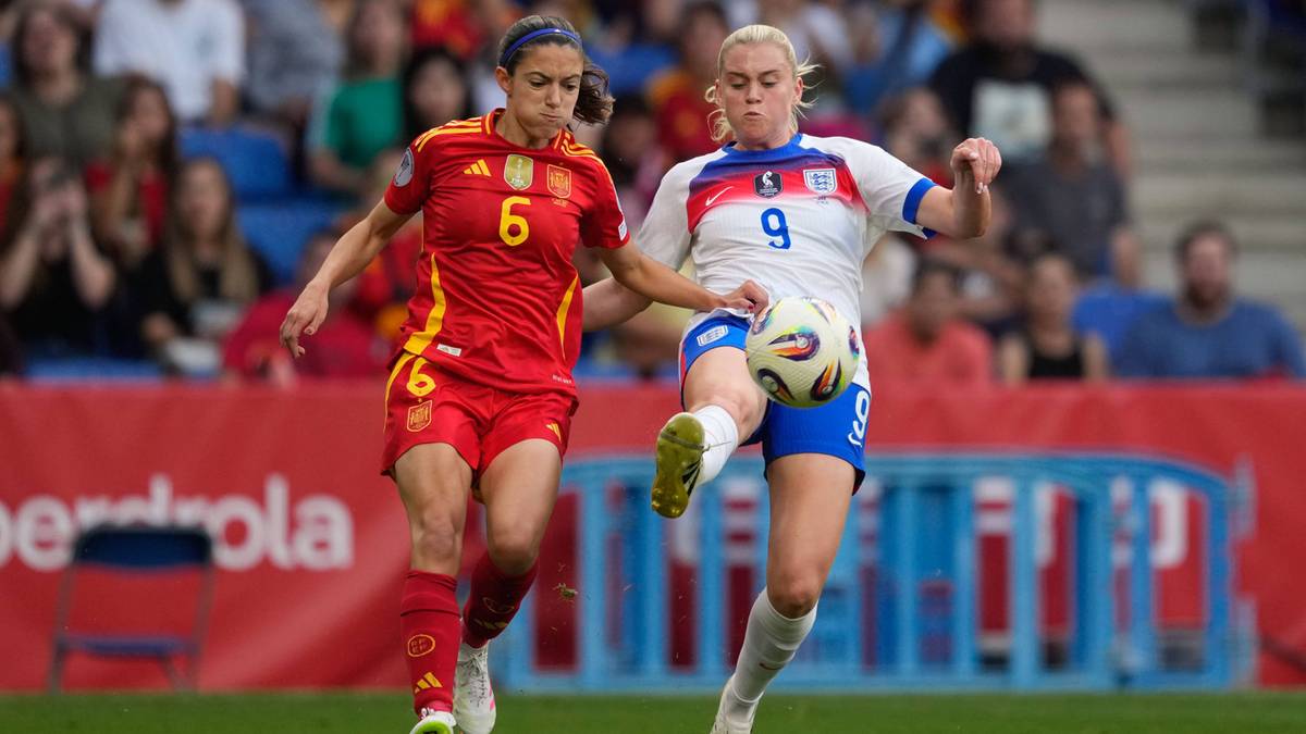 Dwie piłkarki w trakcie meczu. Jedna w czerwonej koszulce z numerem 6, druga w białej koszulce z niebieskimi detalami i numerem 9. Piłka znajduje się między nimi.