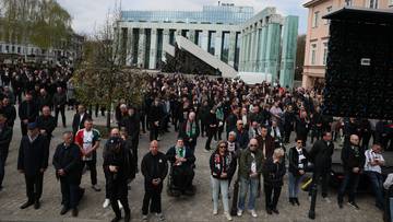 Tłum ludzi zgromadzonych na zewnątrz, przed budynkiem.