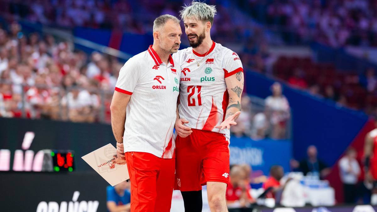 Siatkarz Tomasz Fornal, ubrany w biało-czerwoną koszulkę z numerem 21, rozmawia ze swoim trenerem podczas meczu.