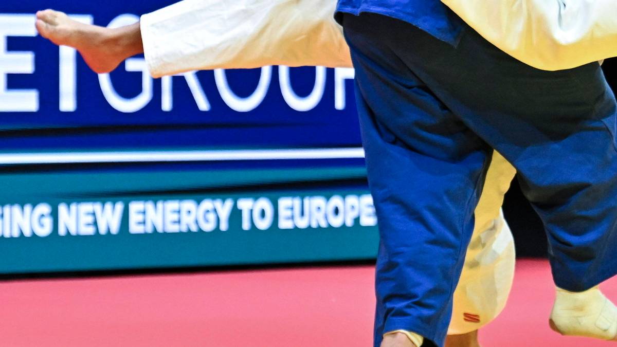 Dwóch judoków walczy na macie podczas zawodów.