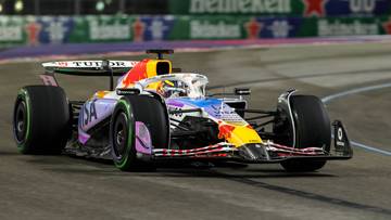 Kolorowy bolid Formuły 1 ściga się po torze.