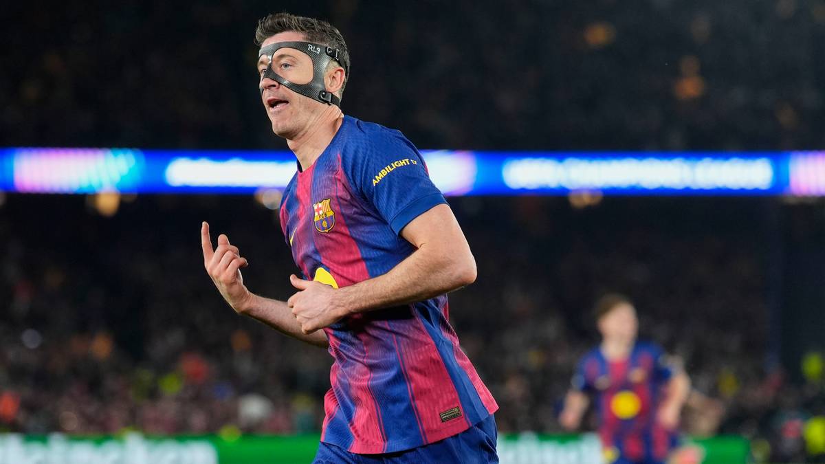 Robert Lewandowski w masce ochronnej na twarzy, w barwach FC Barcelony, biegnie po boisku i celebruje bramkę.