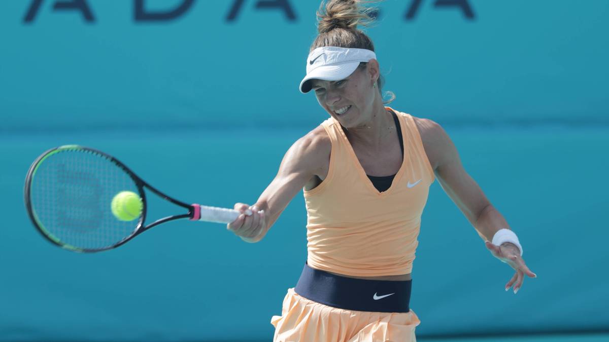 Kobieta grająca w tenisa, uderzająca piłkę rakietą.