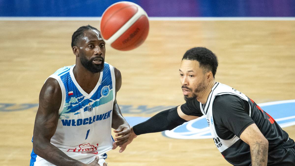 Dwóch zawodników drużyny koszykarskiej podczas meczu. Jeden zawodnik w białej koszulce z napisem WŁOCŁAWEK i numerem 1 na plecach, wznosi piłkę do rzutu. Drugi zawodnik w czarnej koszulce próbuje go zablokować.