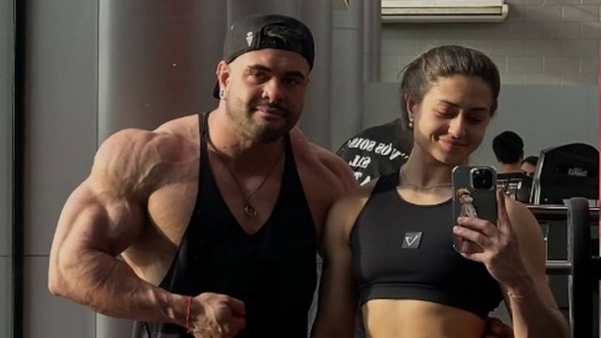 Umięśniony mężczyzna i kobieta robiący selfie w siłowni.