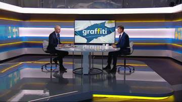 Dwóch mężczyzn siedzi przy stole w studiu telewizyjnym, na ekranie za nimi widnieje napis "graffiti".