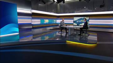 Dw&oacute;ch mężczyzn siedzi przy okrągłym stole w nowoczesnym studiu telewizyjnym. Na ekranie za nimi widnieje napis "graffiti".
