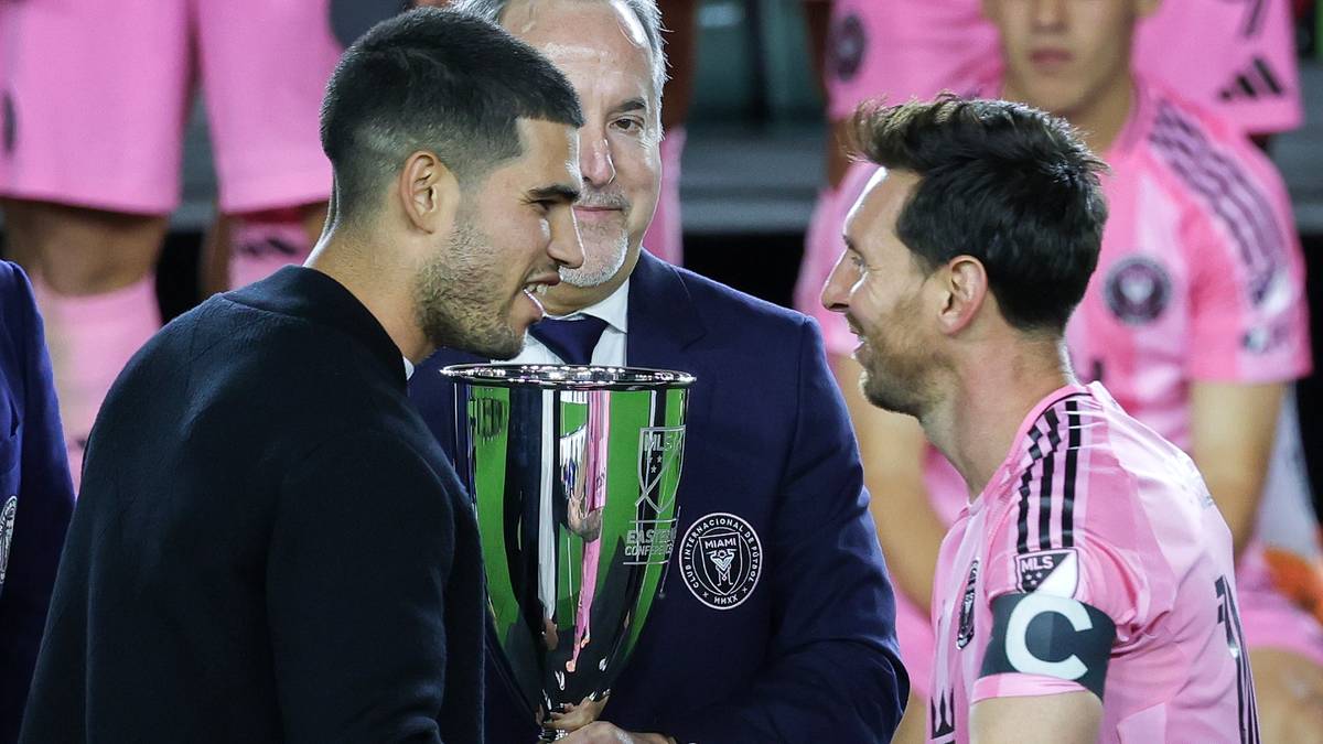 Carlos Alcaraz i Leo Messi trzymają trofeum