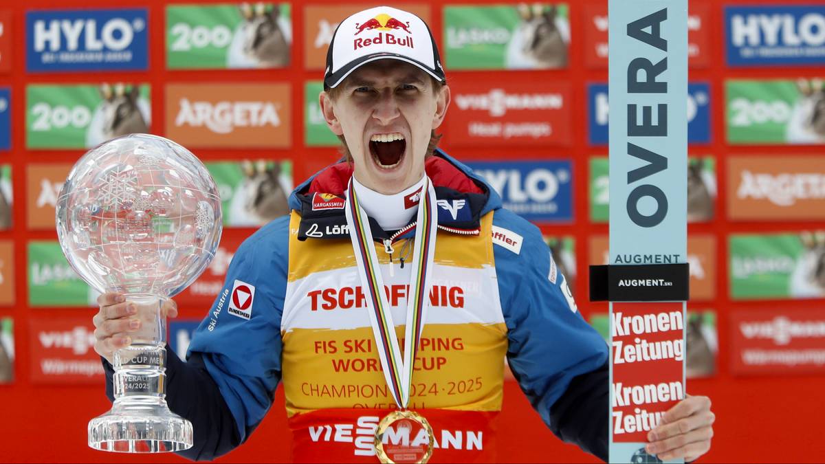 Skoczek narciarski w czapce z daszkiem i medalem na szyi, trzymający kryształową kulę i tablicę z napisem "OVERALL", z okrzykiem radości na twarzy.