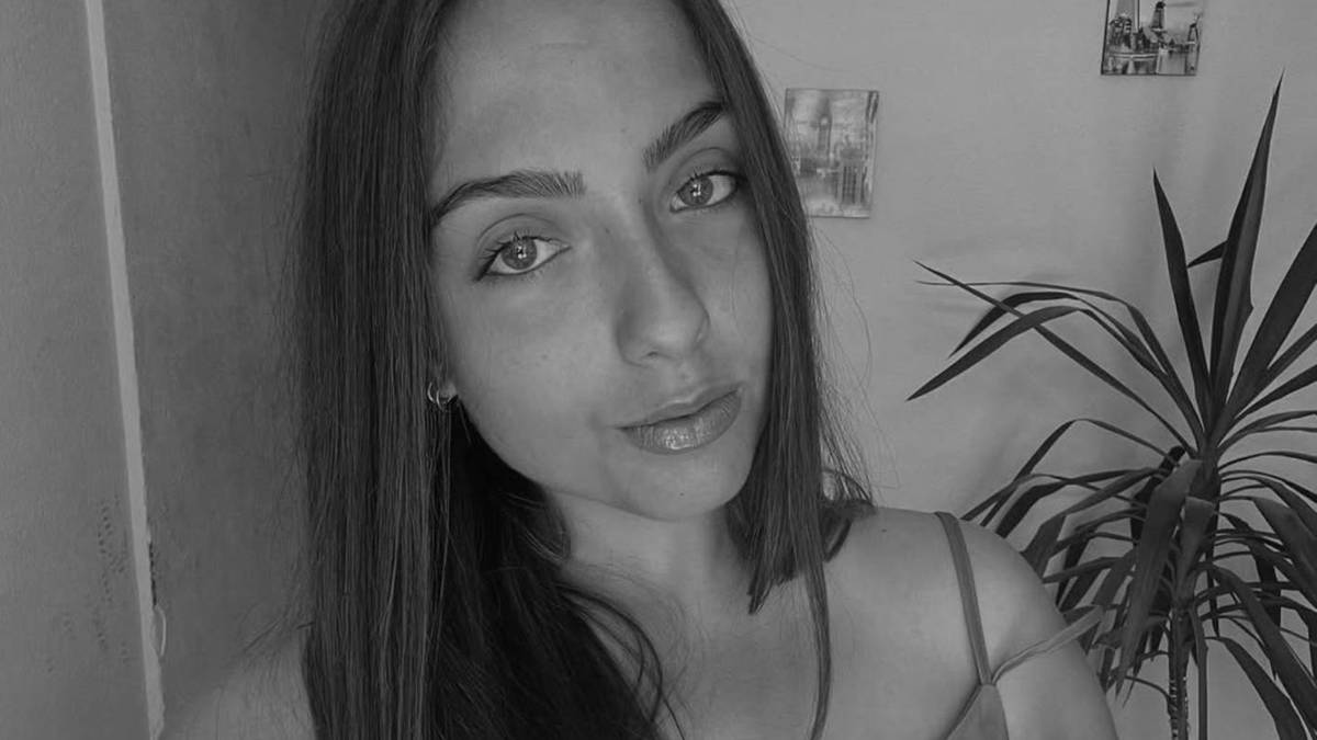 Czarno-białe zdjęcie zbliżenie na twarz młodej kobiety, która patrzy w obiektyw.