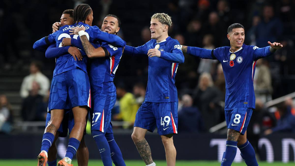 Piłkarze w niebieskich strojach świętują razem na boisku piłkarskim.