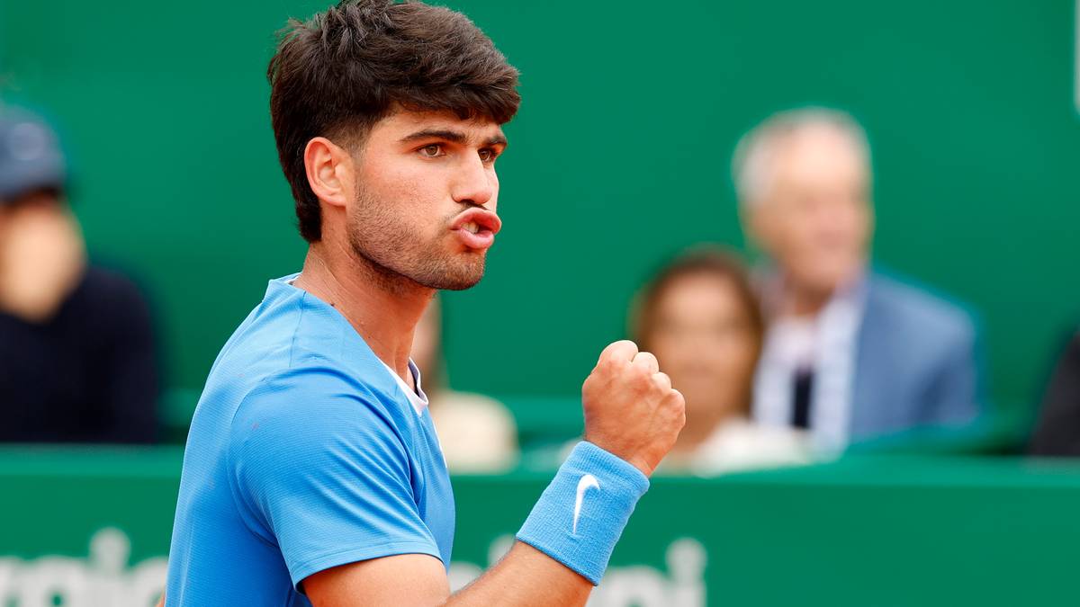 Carlos Alcaraz z uniesioną pięścią podczas meczu tenisowego.