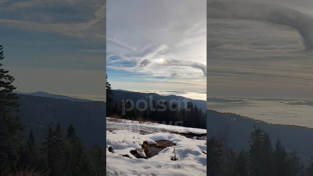 Malowniczy widok na pasmo górskie pokryte śniegiem, z niecodziennym, spiralnym kształtem chmur na niebie.