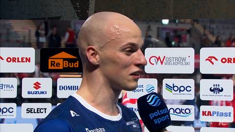 Portret Jakuba Tokarza podczas wywiadu, z widocznymi logotypami sponsor&oacute;w w tle.