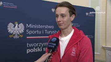 Paweł Wąsek, polski sportowiec, udziela wywiadu. Na jego piersi widoczny symbol olimpijski.