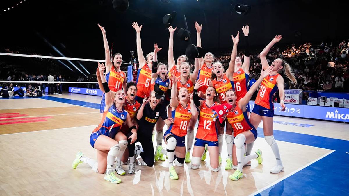 Drużyna siatkarek świętuje zwycięstwo na boisku z uniesionymi rękami.