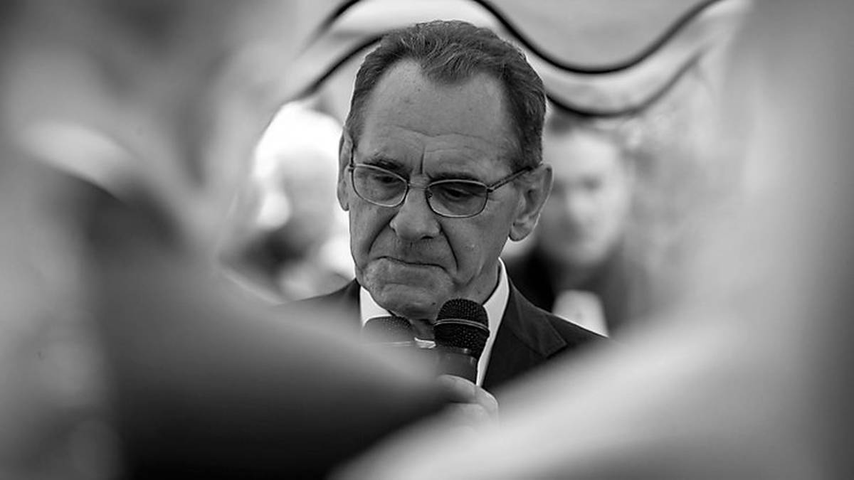 Portret Ryszarda Szurkowskiego, legendy polskiego kolarstwa, trzymającego mikrofon.