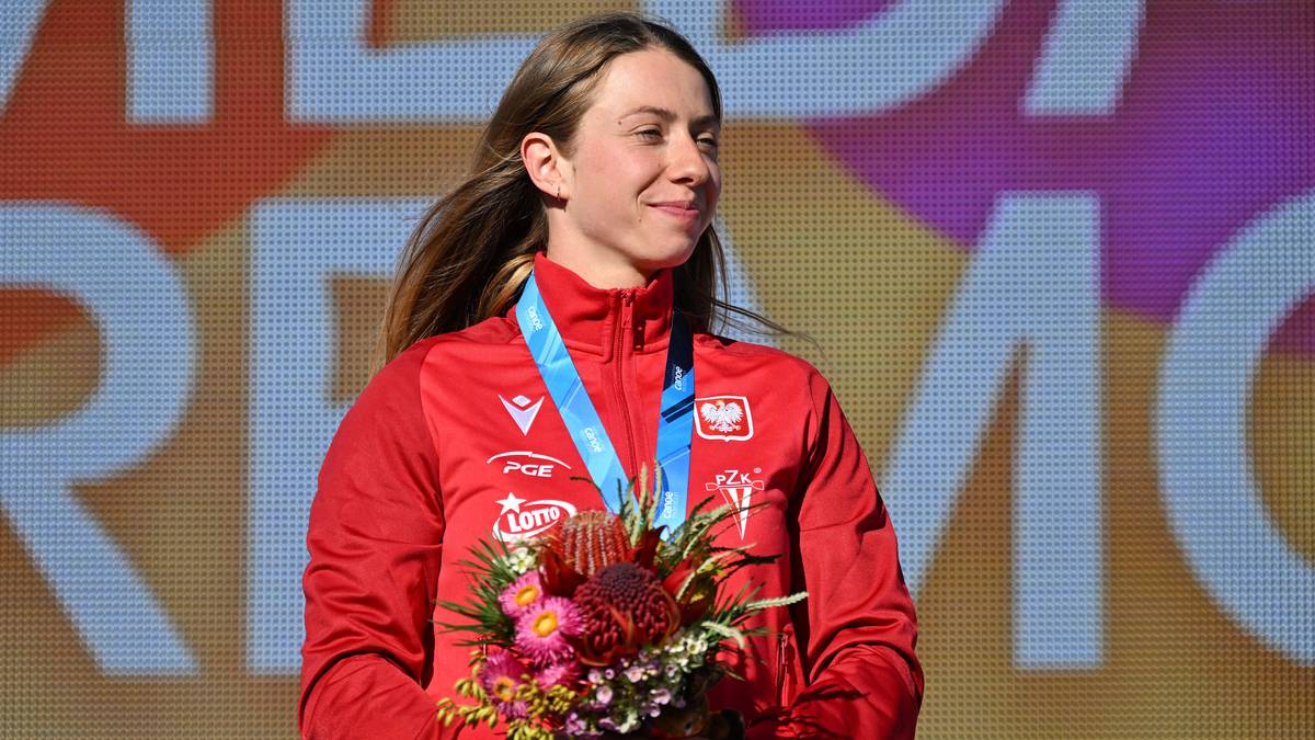 Iga Świątek z bukietem kwiatów i medalem.