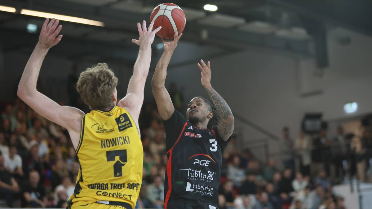 Gracz w żółtej koszulce z numerem 7 próbuje zablokować rzut gracza w czarnej koszulce z numerem 3.