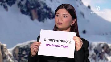 Kobieta trzyma białą kartkę z napisem "#muremzaPolą" i "#WeAreOneTeam". W tle widoczne są ośnieżone g&oacute;ry.