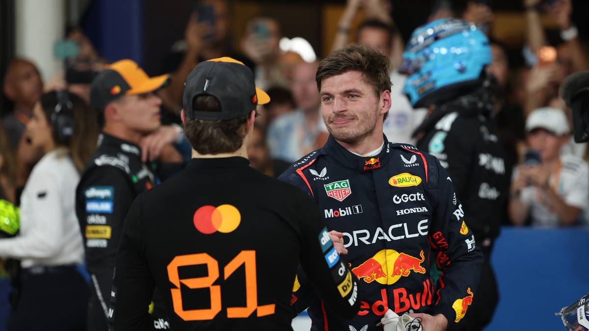 Dwóch kierowców Formuły 1 w kombinezonach wyścigowych, Max Verstappen i Lando Norris, rozmawia ze sobą po zawodach.