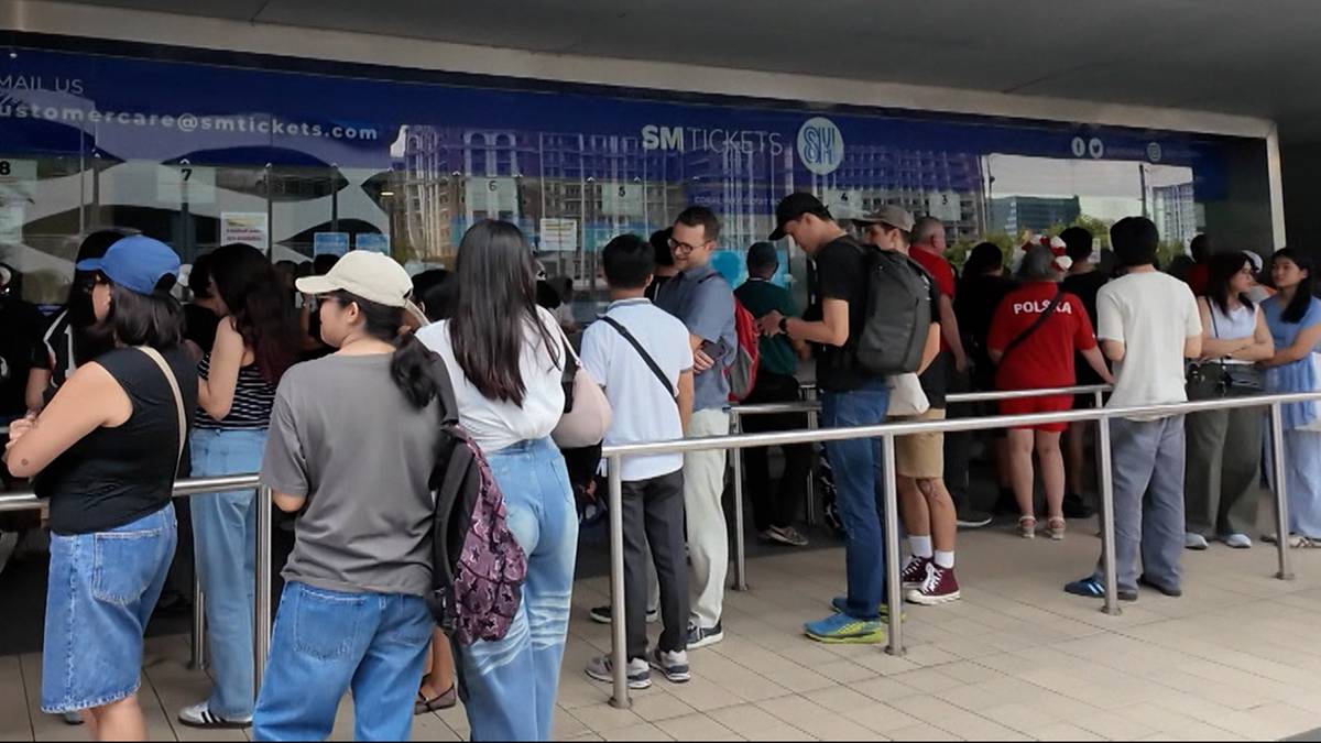 Ludzie stoją w kolejce przed budynkiem, oczekując na mecz.