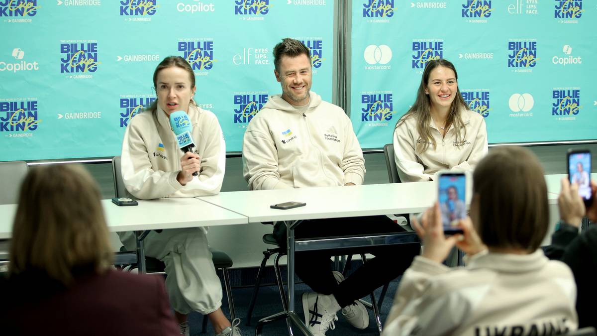 Trzy osoby siedzące przy stole konferencyjnym, dwie kobiety i mężczyzna, z mikrofonem przed jedną z kobiet.