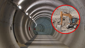 Wnętrze budowanego tunelu kolejowego z oświetleniem oraz w okręgu koparka pracująca na placu budowy.