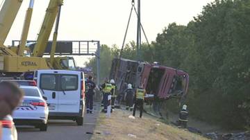Uruchomiony żuraw podnosi przewr&oacute;cony autokar po tragicznym wypadku. Na miejscu pracują służby ratownicze i policja.