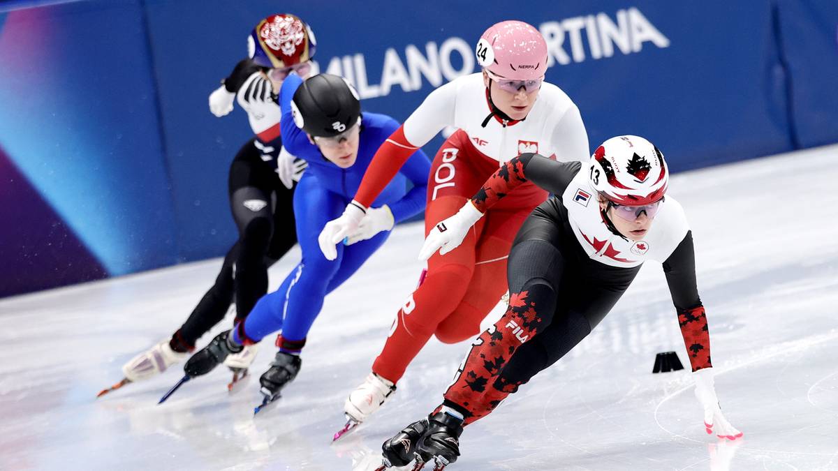 Zawodnicy w łyżwiarskim stroju sportowym ścigają się na lodowisku, pochyleni do przodu.