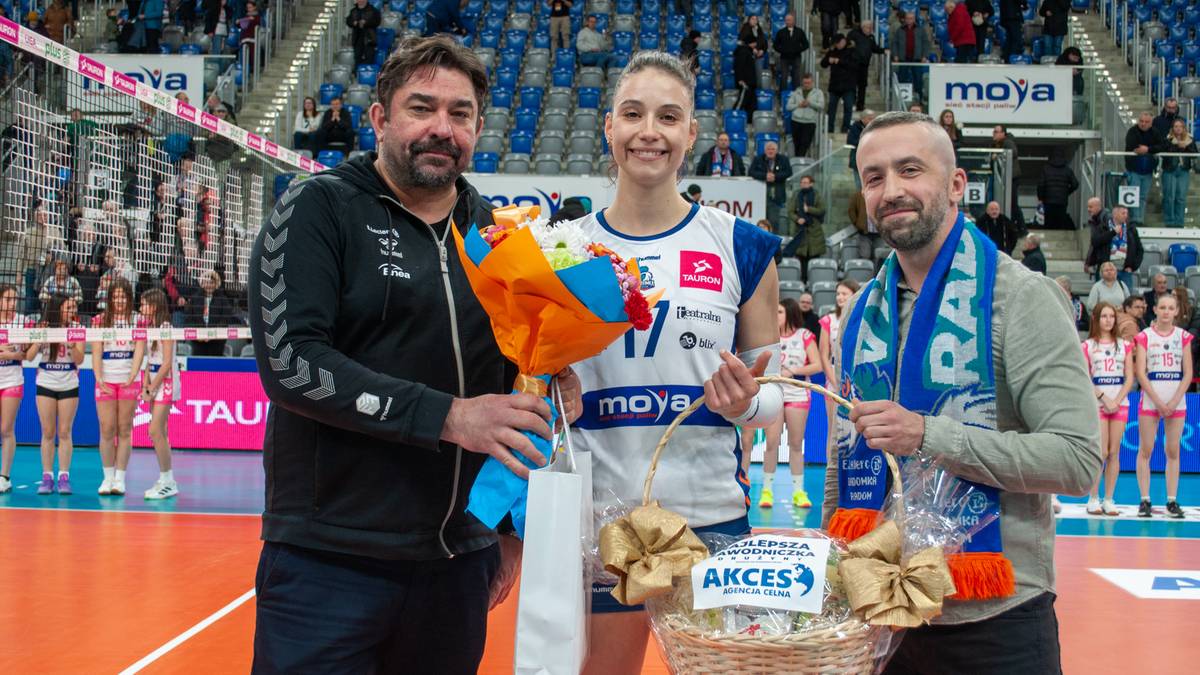 Trzy osoby na boisku siatkarskim, w tym zawodniczka w stroju sportowym z numerem 17.