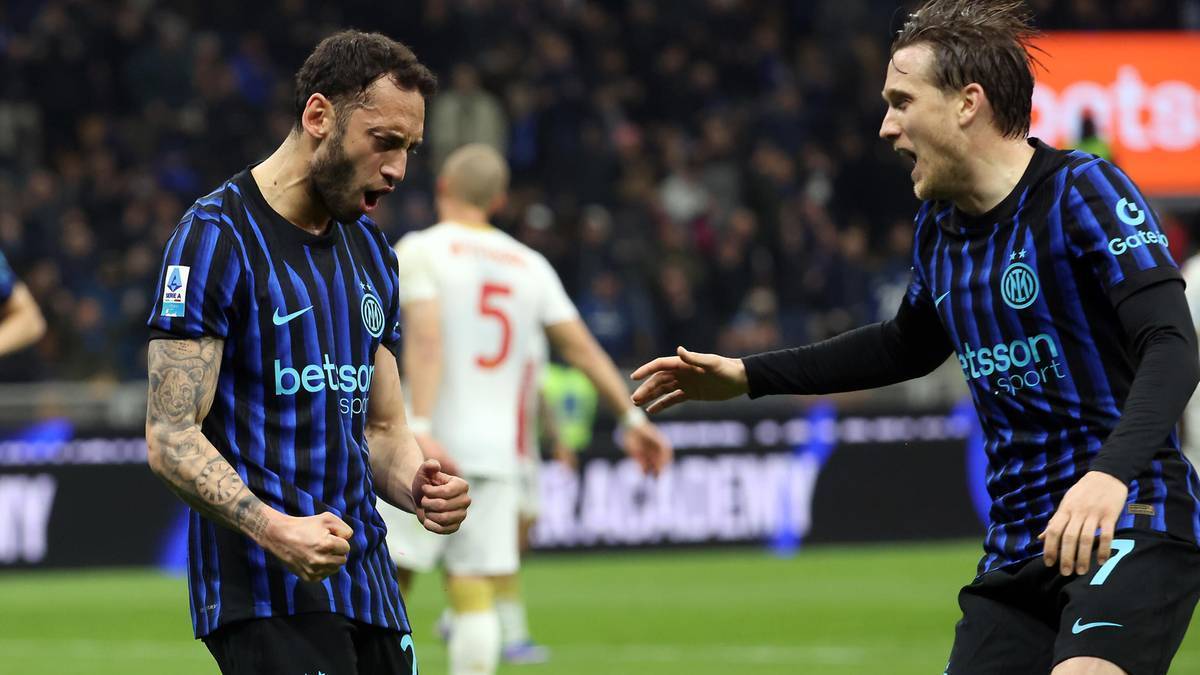 Dw&oacute;ch piłkarzy Interu Mediolan cieszy się po zdobytej bramce na tle innych zawodnik&oacute;w i trybun.