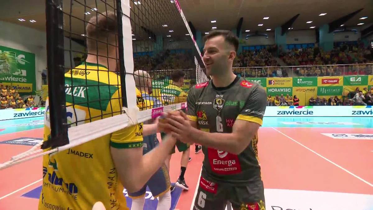 Dwóch siatkarzy ściska sobie dłonie nad siatką po meczu siatkówki.