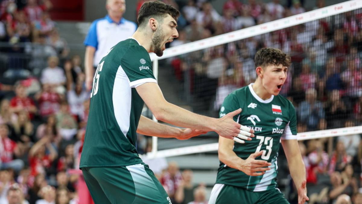 Dwóch polskich siatkarzy w zielonych strojach świętuje zdobycie punktu podczas meczu.
