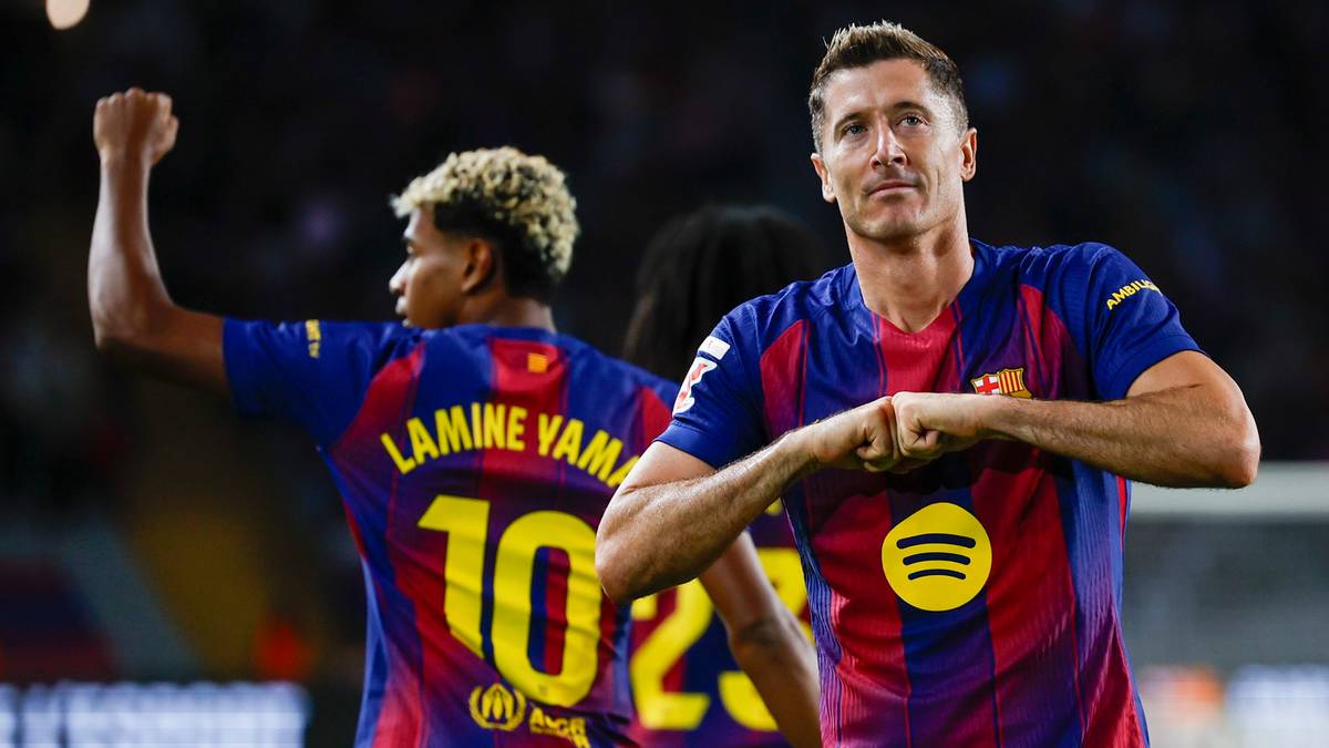 Dwóch piłkarzy FC Barcelony w niebiesko-bordowych koszulkach świętuje bramkę.