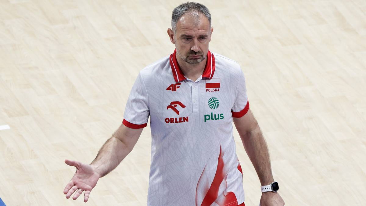 Nikola Grbić, trener reprezentacji Polski w siatkówce, stoi na boisku i gestykuluje rękami, wyrażając swoje niezadowolenie.