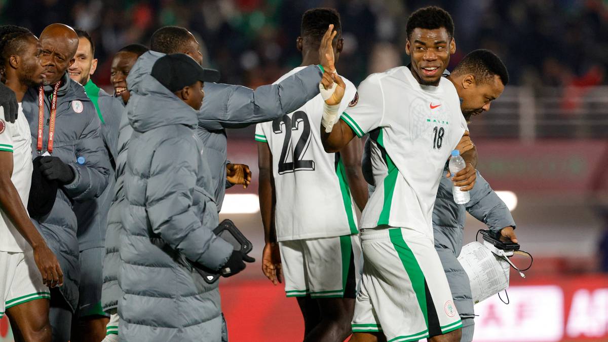 Piłkarze świętujący po meczu na boisku.