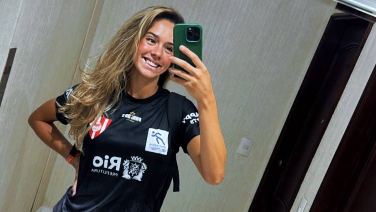 Młoda kobieta w czarnej koszulce sportowej robi sobie selfie telefonem kom&oacute;rkowym