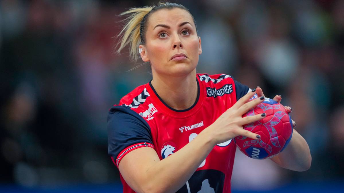 Zawodniczka piłki ręcznej trzyma piłkę, skupiona na grze.