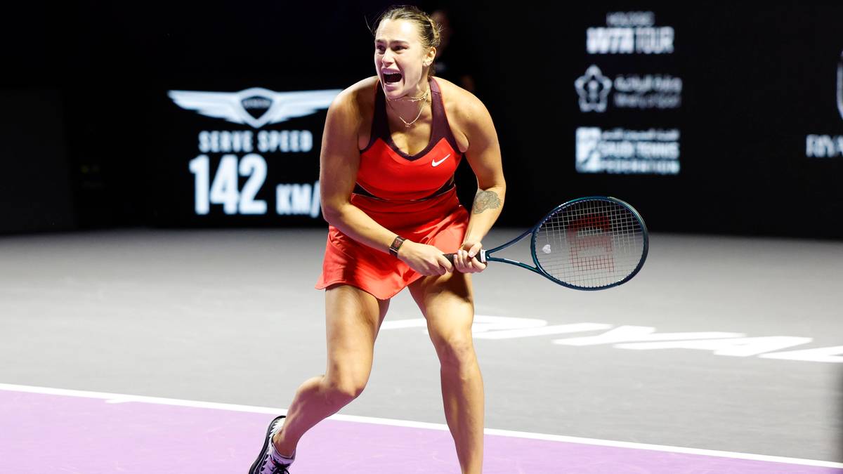 Tenisistka w czerwonej sukience na korcie, w trakcie gry.