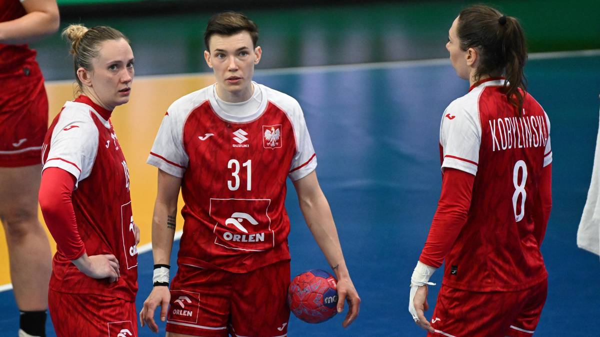 Trzy zawodniczki w strojach piłki ręcznej, jedna z nich trzyma piłkę.