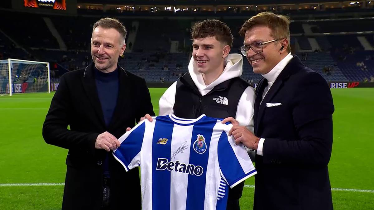 Trzech mężczyzn pozuje do zdjęcia na boisku piłkarskim. Dw&oacute;ch trzyma koszulkę FC Porto.